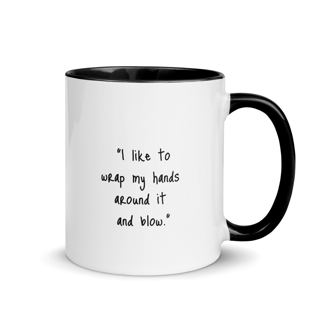 ceramic mug with colored rim and handle. The text "I like to wrap my hands around it and blow" is written on one side.